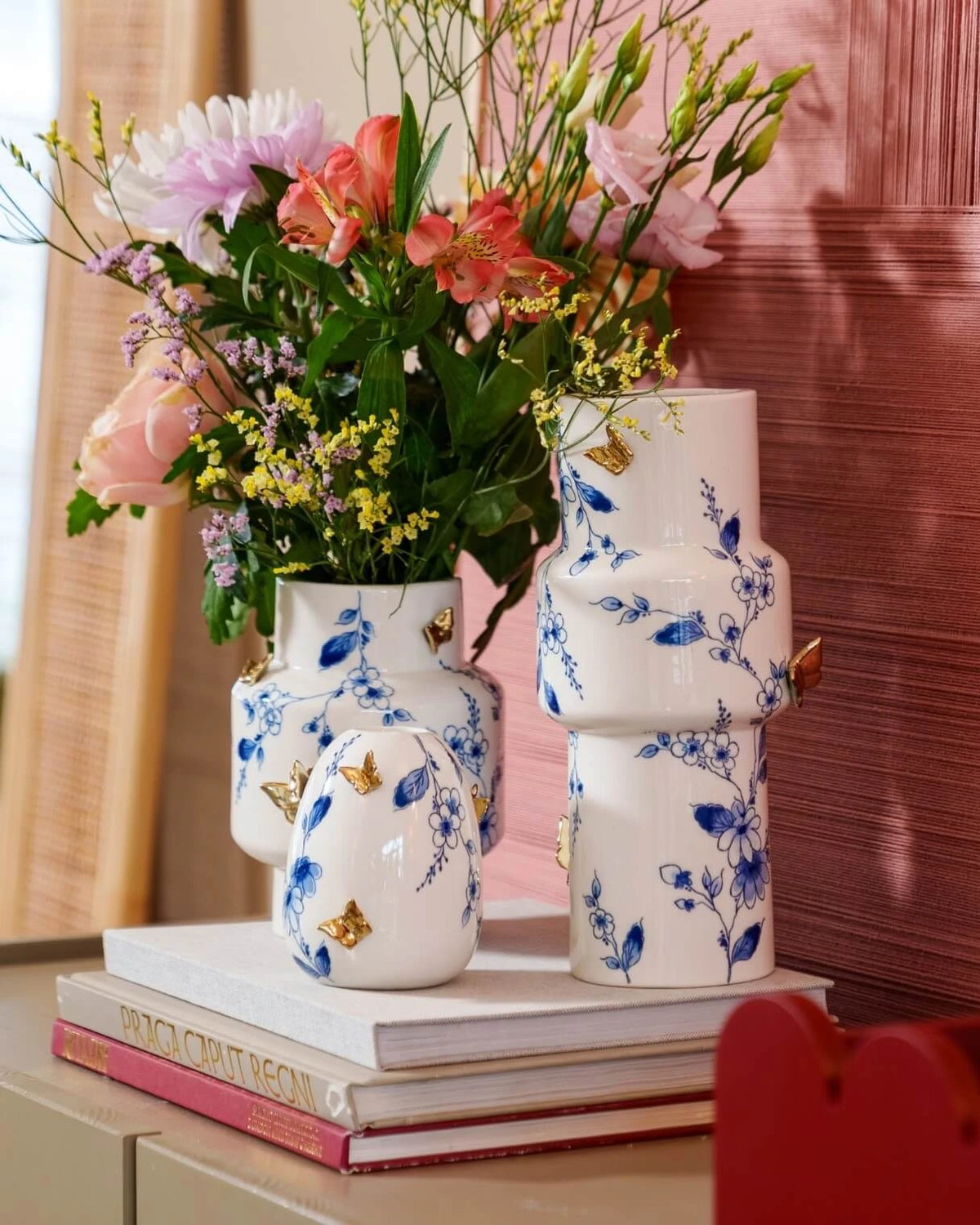 Cylindervase med små blå blomster med 3D guldsommerfugle